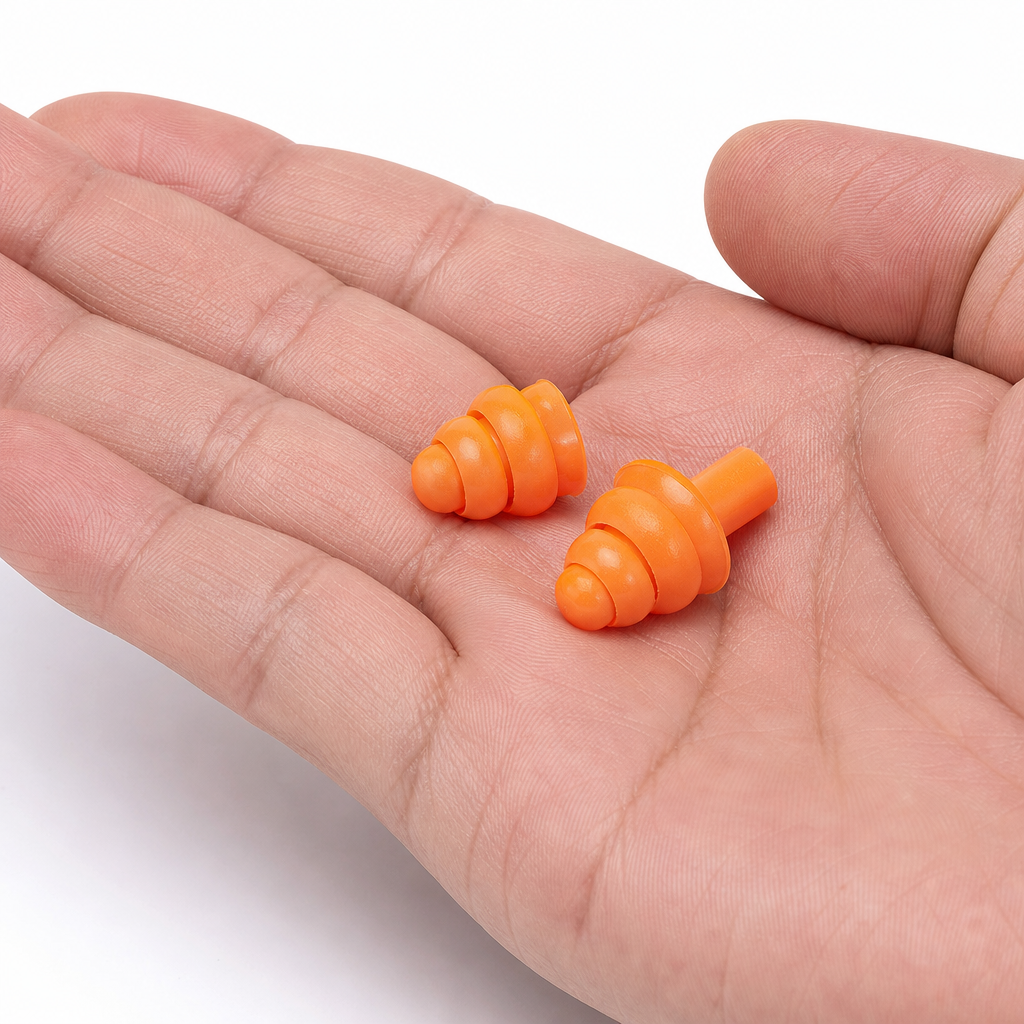 Close-up view of ear plugs held in an open hand displaying size and design