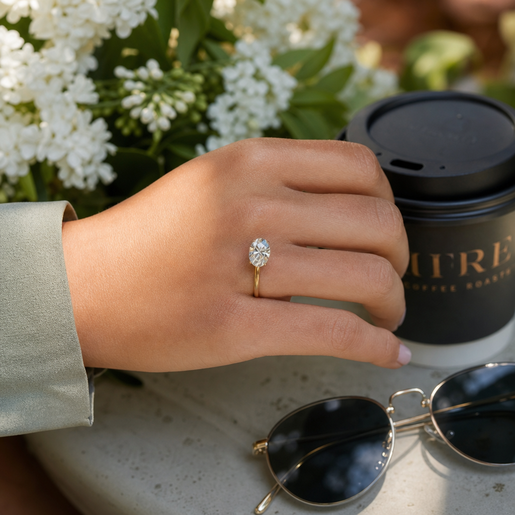 Person wearing lab-created diamond engagement ring in outdoor natural light setting