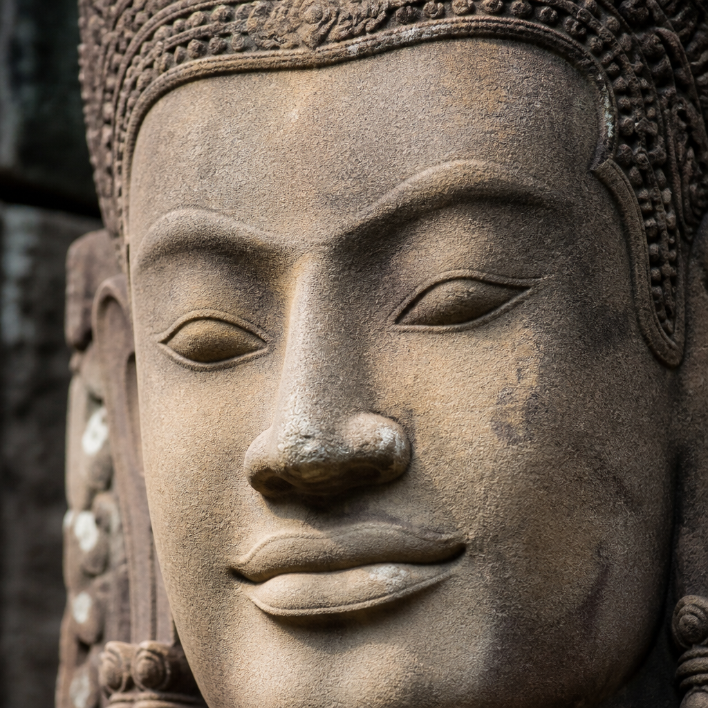 Detailed sandstone Khmer sculptural head showing refined carving and weathered patina
