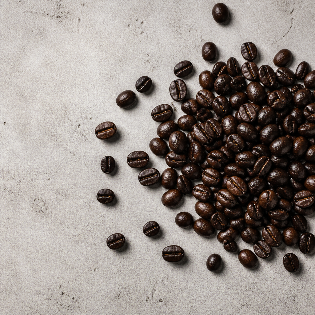 Close-up overhead view of dark espresso roast coffee beans on concrete