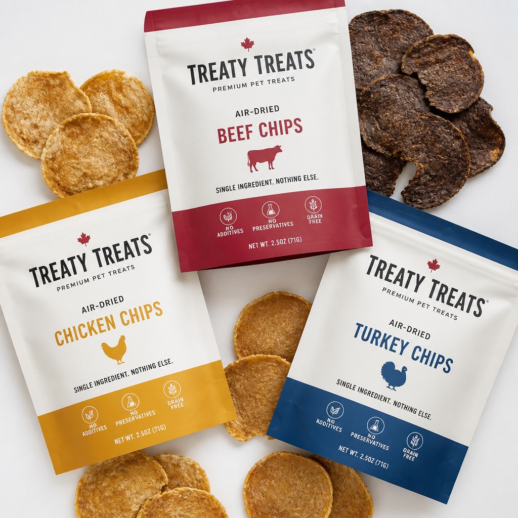 Flat lay of Treaty Treats premium pet treat packages showing beef, chicken, and turkey varieties with visible ingredient lists