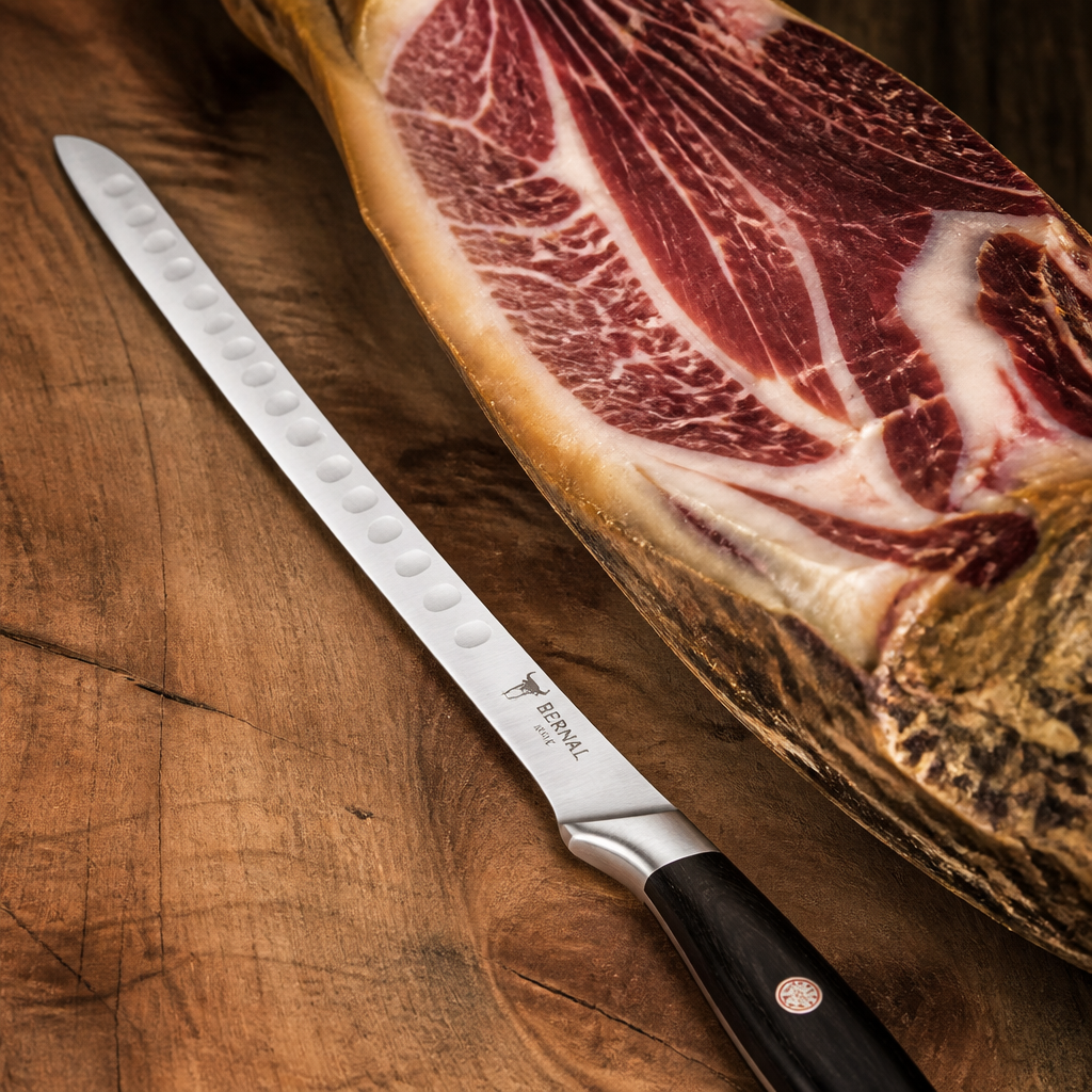 Cuchillo jamonero premium junto a jamón ibérico de bellota mostrando la calidad de la hoja